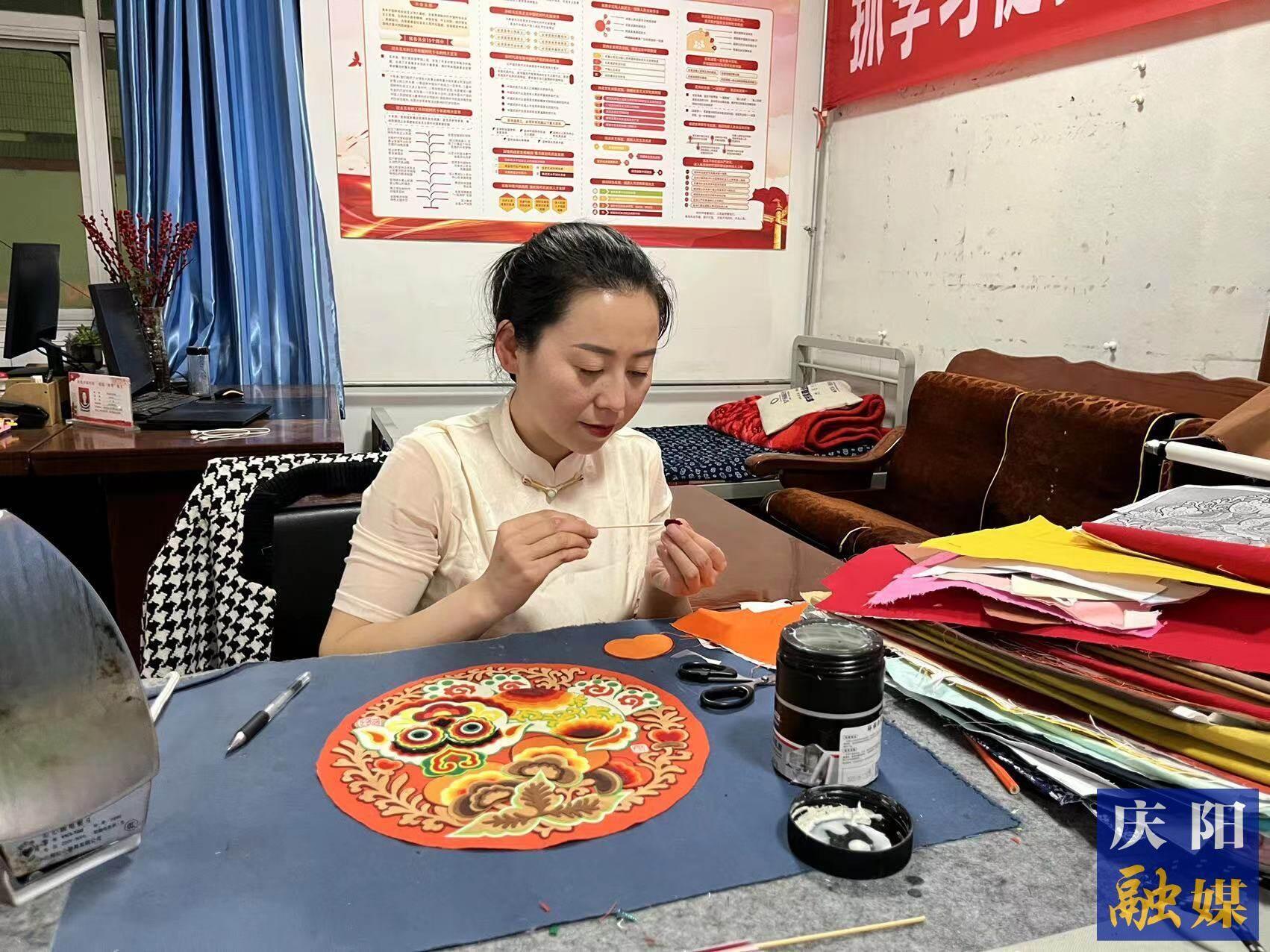 李慶英正在創(chuàng)作布貼畫(huà)作品。